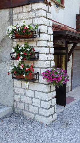 two flower boxes on a brick wall with flowers at Villaggio Hotel Aquila in Calliano