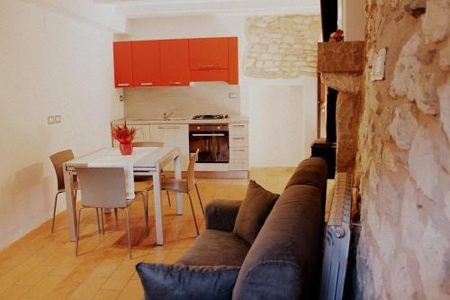 sala de estar y cocina con sofá y mesa en Casa Vacanze L'arco di Fondarca, en Cagli