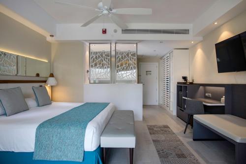 a hotel room with a bed and a desk at Catalonia Royal La Romana Adults Only - All Inclusive in Bayahibe