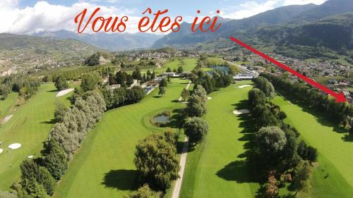 a view of a golf course with a red arrow that says yours eyes irt at Studio indépendant à Grône in Grône
