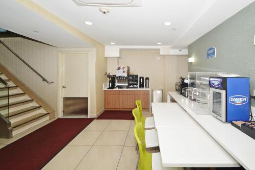 a kitchen with a table, chairs and a microwave at Corona Hotel New York - LaGuardia Airport in Queens