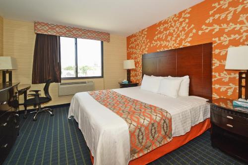 ein Hotelzimmer mit einem großen Bett und einem Schreibtisch in der Unterkunft Corona Hotel New York - LaGuardia Airport in Queens