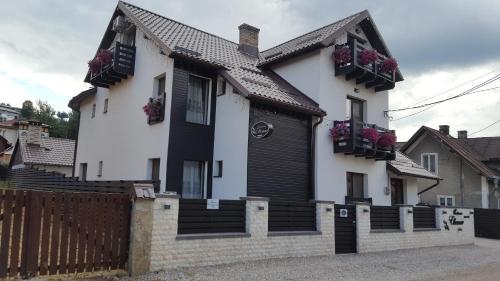 a black and white house with flower boxes at Pensiunea Ellemar in Vatra Dornei