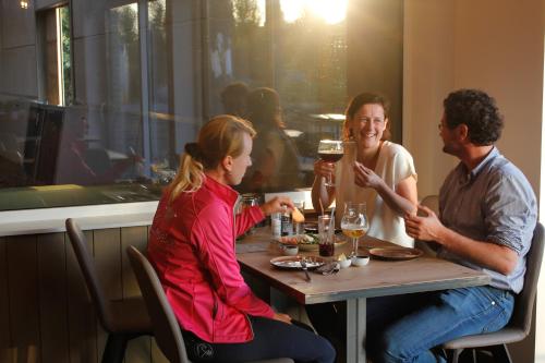 eine Gruppe von Menschen, die in einem Restaurant an einem Tisch sitzen in der Unterkunft Ruiterhof B&B/Hostel in Bredene