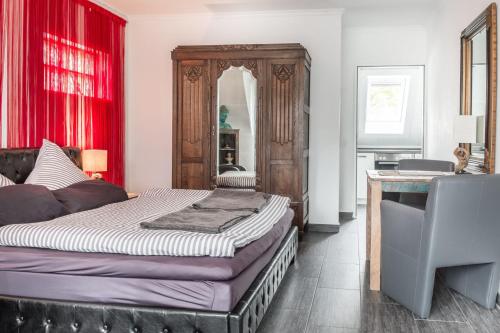 a bedroom with a large bed with red curtains at Sandkorn-Büsum in Büsum