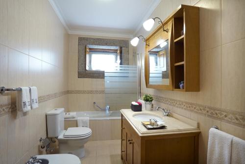 a bathroom with a toilet and a sink and a mirror at Casa da Torre in Pico