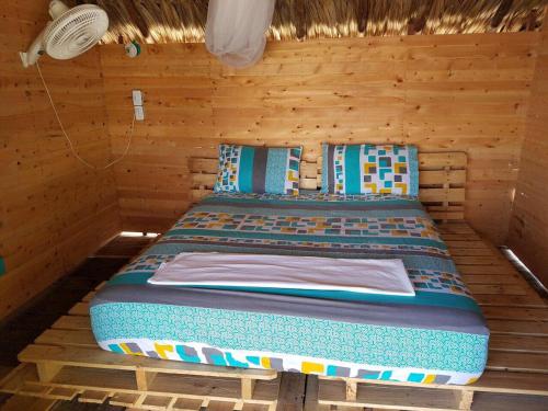 a bed that has a blue blanket on it at The Wizard & Bar BARU in Playa Blanca