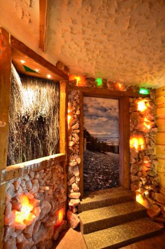 a room with a stone wall and a staircase with lights at Noclegi u Banysia w sercu Gór Świętokrzyskich in Krajno Pierwsze