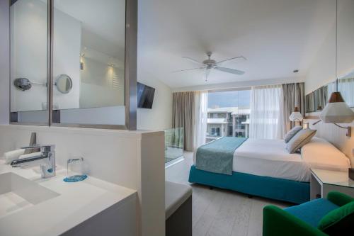 a hotel room with a bed and a bathroom at Catalonia Royal La Romana Adults Only - All Inclusive in Bayahibe