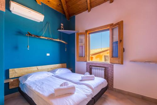 バゲリーアにあるSolemar Sicilia - Residence Mer et Soleilの青いベッドルーム(ベッド1台、窓付)