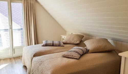 a bedroom with two beds with pillows on it at Marių pelėdos in Preila