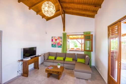Fleurs d'épices في Anse-Bertrand: غرفة معيشة مع أريكة وتلفزيون