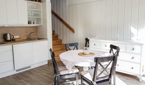 a kitchen with a table and chairs in a room at Marių pelėdos in Preila