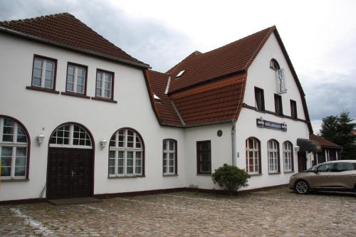 ein weißes Gebäude mit braunem Dach in der Unterkunft Hotel Zum goldenen Stern in Leibsch