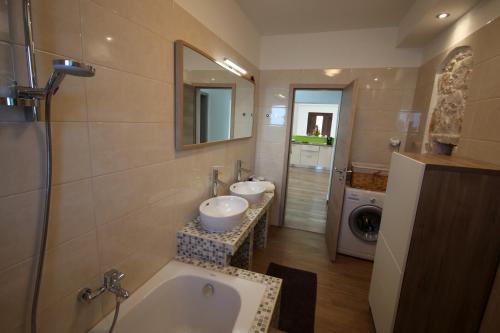 a bathroom with a tub and a sink and a washing machine at Apartment Luna in Valtura