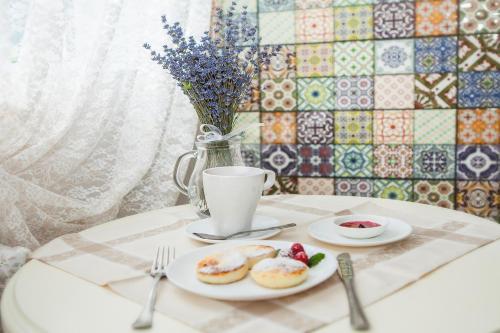 a table with plates of donuts and a cup of coffee at Mini Hotel Ryleev in Kharkiv