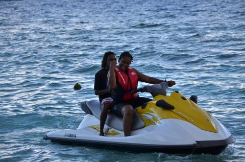 two people riding on a jet ski in the water at Holiday Haven Ukulhas in Ukulhas