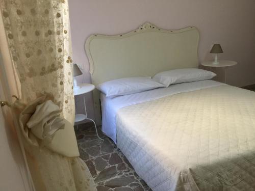 1 dormitorio con cama blanca y cortina en La Perla del Mare en Martinsicuro