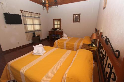 sypialnia z dwoma łóżkami i ręcznikami na nich w obiekcie Parador Monte Carmelo w mieście Oaxaca