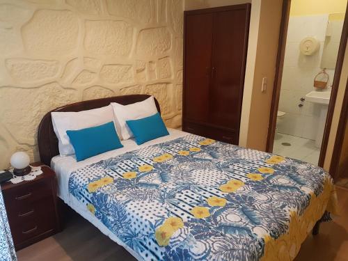 a bedroom with a bed with a blue and white comforter at Caldeira Guest House in Porto