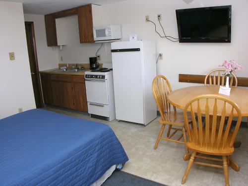 a small kitchen with a table and a white refrigerator at Neptune Motel Maine in Old Orchard Beach