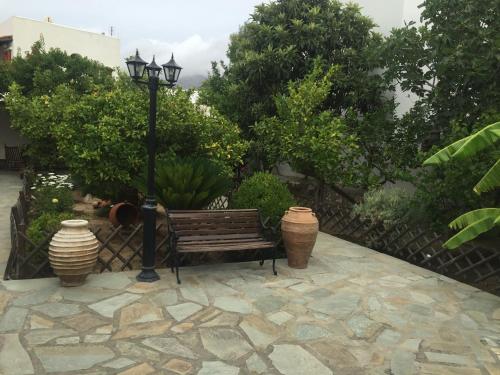 a park bench next to a street light and trees at Akti Rooms And Studios in Livadion