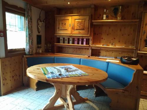 a kitchen with a wooden table and a blue bench at Schwaighof in Oberau