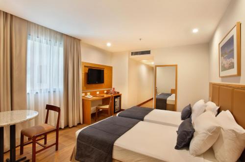 a hotel room with a bed and a desk at Windsor Excelsior Copacabana in Rio de Janeiro