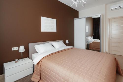 ein Schlafzimmer mit einem großen Bett und einem Spiegel in der Unterkunft Arcadia Villa Apartments in Odessa