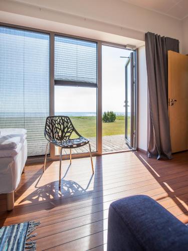 a bedroom with a chair in front of a window at Harbor House Lõmala in Lõmala