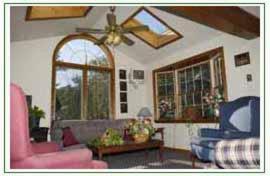 a living room with a couch and a ceiling fan at Lodge at Kennebunk in Kennebunk