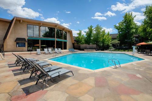 a swimming pool with chairs and a building at Red Lion Hotel Redding in Redding