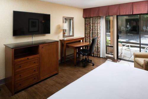 a hotel room with a bed and a desk with a television at Red Lion Hotel Redding in Redding