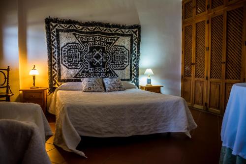 a bedroom with a bed with a headboard and two lamps at Casa De La Fuente in Bubión