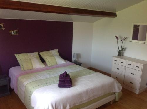 - une chambre dotée d'un lit avec un mur violet dans l'établissement Au mas des graviers, à Salavas