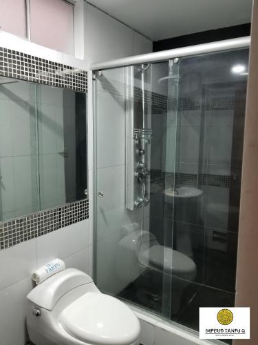 a bathroom with a toilet and a glass shower at Imperio Tanpu Q in Lima
