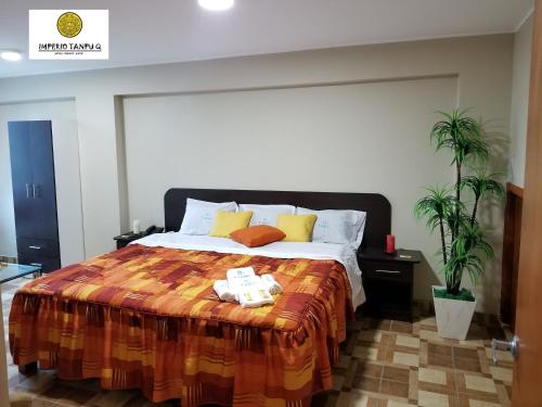 a bedroom with a large bed with yellow pillows at Imperio Tanpu Q in Lima