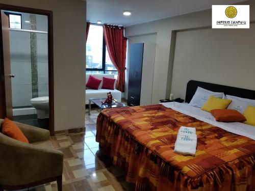 a bedroom with a large bed and a living room at Imperio Tanpu Q in Lima