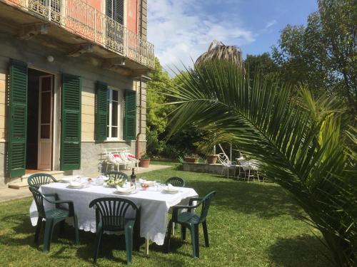 una mesa con un mantel blanco y sillas en un patio en Villa Carlotta, en Sarzana