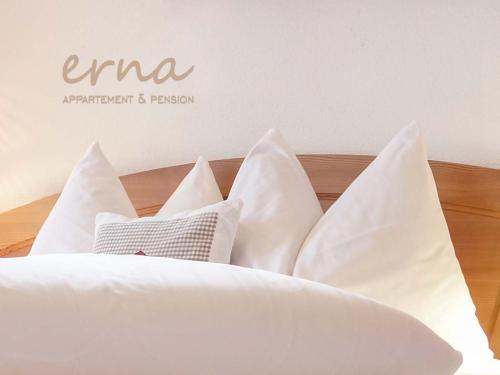a bed with white pillows on top of it at Pension Apartment Erna in Resia
