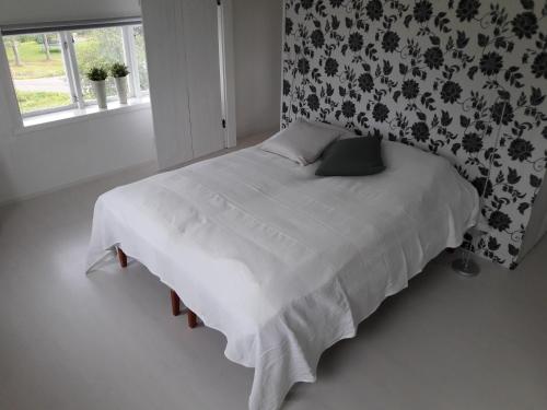 a bedroom with a bed with white sheets and a window at Orsastuguthyrning-Digerberget in Orsa
