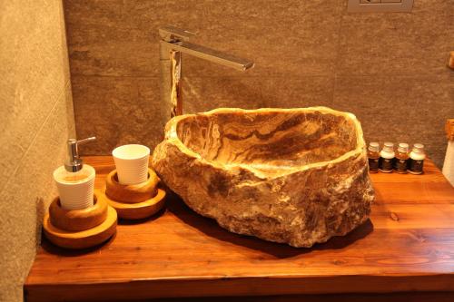a wooden counter with a stone sink with cups on it at Mi Casa Tu Casa in Brusson
