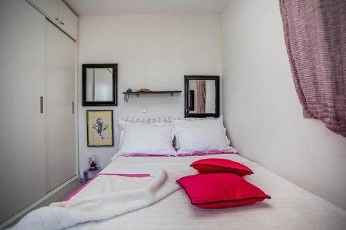 a bedroom with a bed with red pillows on it at Apartments Lux in Makarska