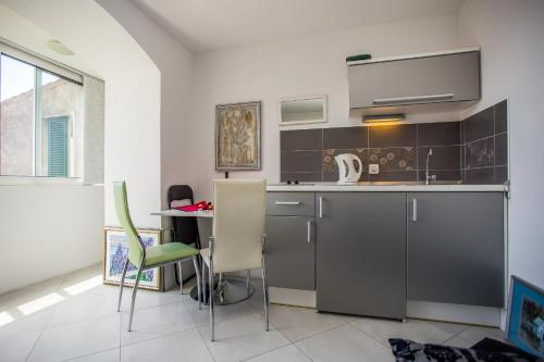 a kitchen with a table and chairs in a room at Apartments Lux in Makarska