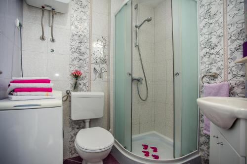 a bathroom with a shower and a toilet and a sink at Apartments Lux in Makarska