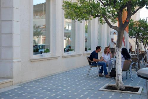 a group of people sitting at a table under a tree at Hotel Gega in Berat