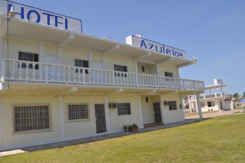 a white building with a balcony on top of it at Hotel Azulejos in Chachalacas