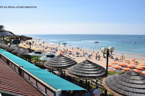 a beach with umbrellas and people on the beach at Pé na Praia in Albufeira