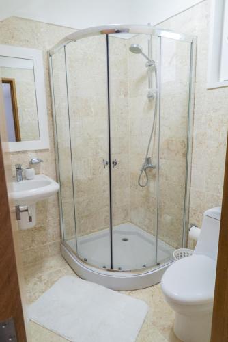a bathroom with a shower with a toilet and a sink at 3BR / 3BA Modern Paradise Loft Condo in Gated Community w/ Daily Housekeeping in Sosúa