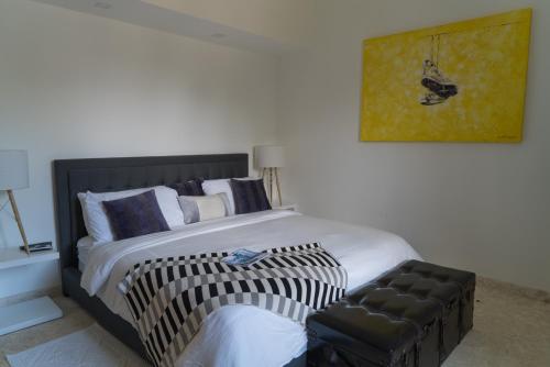 een slaapkamer met een groot bed en een stoel bij 3BR / 3BA Modern Paradise Loft Condo in Gated Community w/ Daily Housekeeping in Sosúa